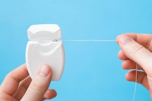 hands holding dental floss container