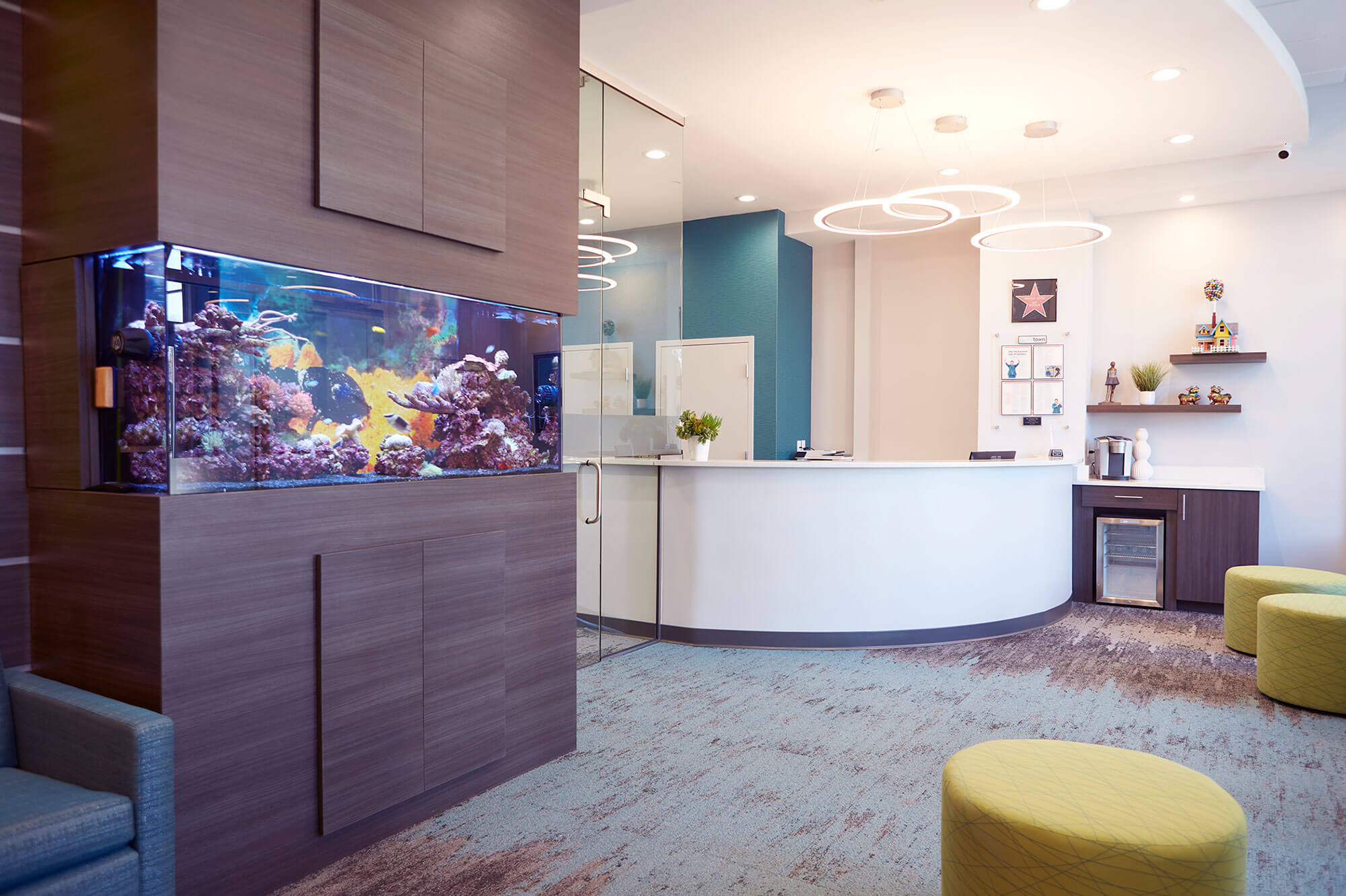 lobby of dental office with fish tank, coffee station and round yellow ottomans