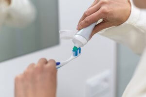 toothpaste being squeezed out on toothbrush