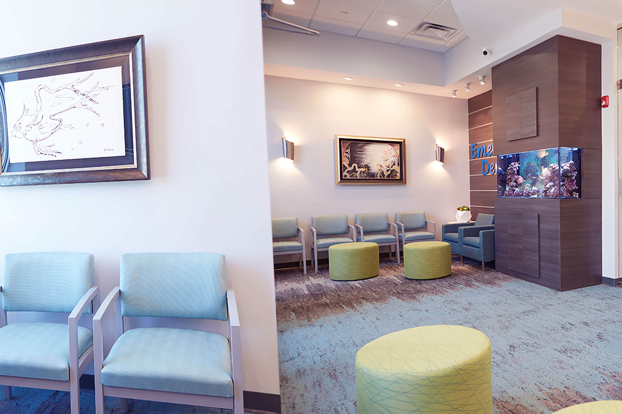 lobby of dental office with fish tank, grey seats and yellow ottomans