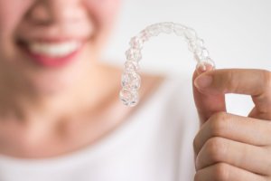 woman holding Invisalign aligner