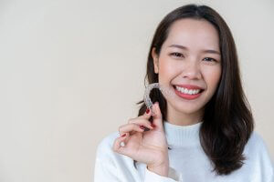 woman holding Invisalign aligner